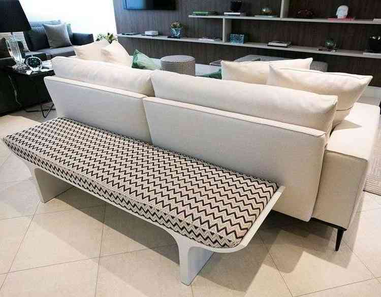 Para aumentar as possibilidades de locais para sentar, você pode colocar um banco atrás do sofá. / Foto: Pinterest - 