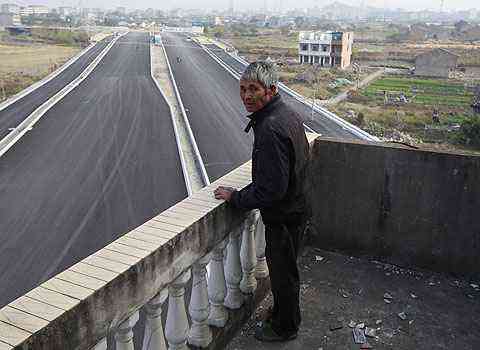 Luo Baogen olha para a estrada que ainda est para ser inaugurada - Aly Song